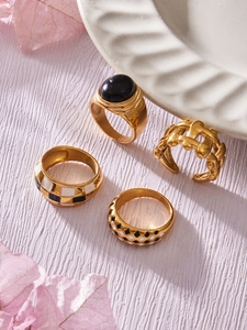Detail of 18k gold plated stainless steel rings with enamel patterns and gemstone