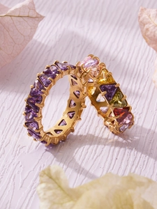 Dettaglio di anelli in oro 18k con zirconi colorati e lati traforati a forma di cuore