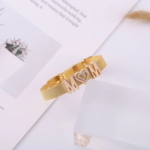 Close-up of golden mesh bracelet with MOM letters and sparkling crystal heart charm