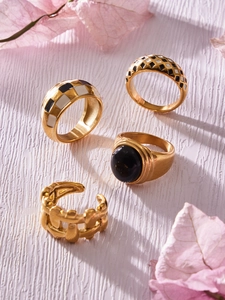 Detailed close-up of 18k gold plated checkerboard enamel and black stone ring set
