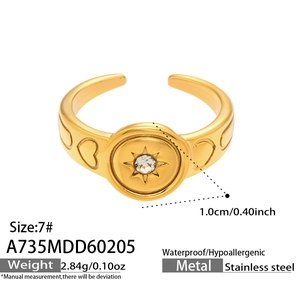 Detail of gold stainless steel star ring with zircon stone and heart engraving