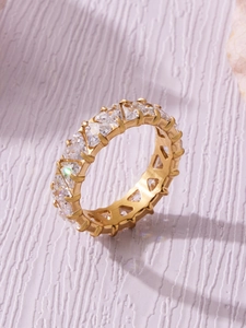 Vista macro di anello placcato oro 18k con zirconi triangolari su sfondo lavanda