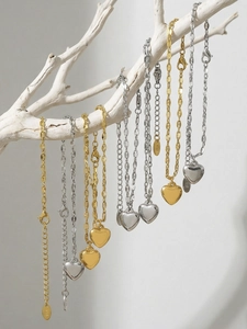 Detailed shot of gold and silver heart pendants on chains with lobster clasp and K18 hallmark