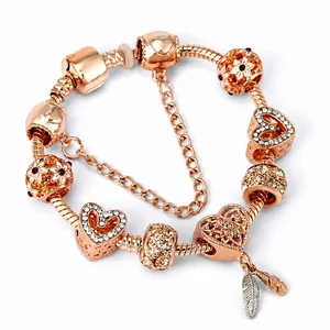 Roségoldenes Schlangenarmband mit funkelnden Herz- und Feder-Charm-Anhängern