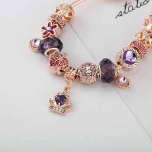 Bracelet maille serpent rose doré avec breloques couronne violette, feuilles et perles