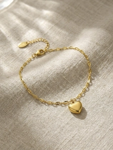 Close-up of gold heart pendant bracelet showing the S925 hallmark on the clasp