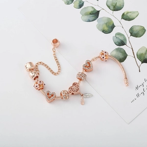 Roségold-Schlangenarmband mit Herz-Anhängern, Blumenperlen und Feder-Elementen