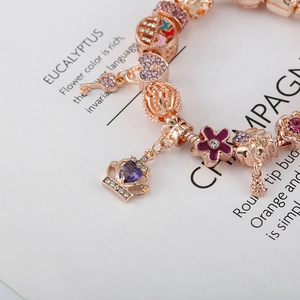 Bracelet à breloques en or rose avec pendentifs couronne et cœur et pierres violettes