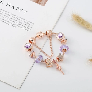 Detailansicht von roségoldenem Bettelarmband mit lila Edelsteinen und Riesenrad-Anhänger