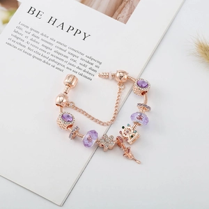 Detailaufnahme von Roségold-Armband mit lila Glasperlen und Herzanhängern