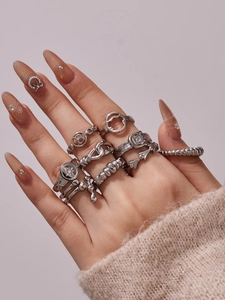 Close-up of stacked silver geometric rings and letter B design on female hand