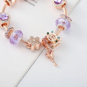 Detailansicht der roségoldenen Schlangenkette mit lila Charms und Blumenanhängern für Damen