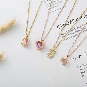 Elegant bear and heart zircon necklaces in gold and rose gold finishes on white background