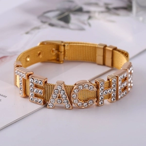 Macro shot of gold stainless steel mesh bracelet featuring sparkling rhinestone TEACHER letters