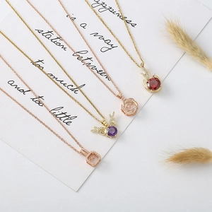 Exquisite gold and rose gold pendant necklaces with zircon inlay on minimalist display