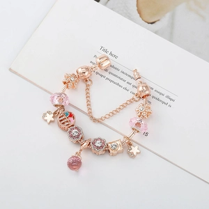 Bracelet rose doré avec perles en verre roses et charmes sertis de zircons cubiques