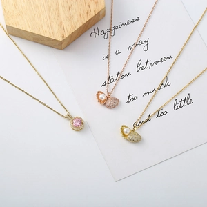 Close-up of shell pearl bear necklaces and pink zircon pendant with fine pavé details