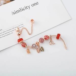 Bracelet maille serpent or rose avec perles en émail rouge et pendentifs feuilles