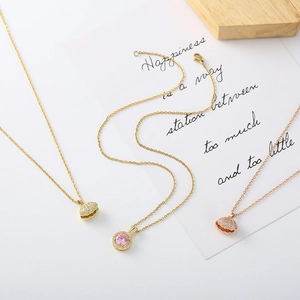 Detailed view of shell-shaped and pink gemstone pendants with micro-pave zirconia settings