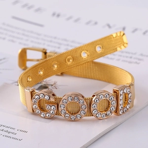 Detail of golden stainless steel mesh bracelet featuring GOOD crystal rhinestone letters