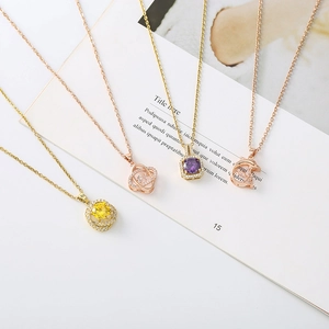 Detail showing various necklace pendants with colorful zircon inlays and delicate chains