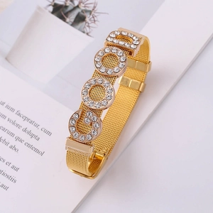 Macro shot of gold mesh strap bracelet with GOOD pavé rhinestone letters decoration
