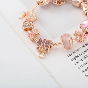 Vue détaillée du bracelet en or rose avec fleur émaillée rose et breloque LOVE