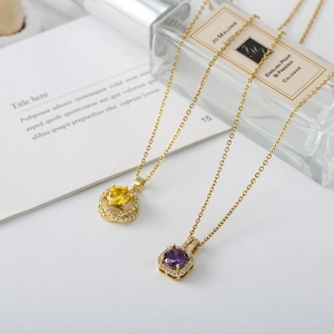 Close-up of gold necklaces with yellow and purple gemstone pendants in a luxury setting
