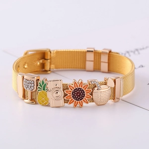 Detail eines goldenen Edelstahl-Armbands mit bunten Emaille-Anhängern auf weißem Grund