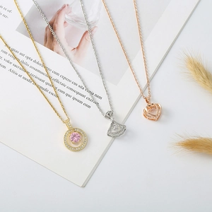 Detailed view of three elegant necklaces featuring shell pearls and zircon bear charms