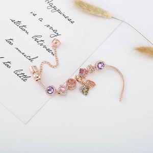 Détail du bracelet maille serpent or rose avec cristaux roses et breloques cœur