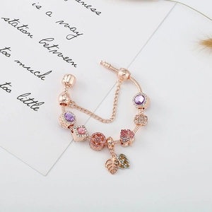 Bracelet maille serpent or rose avec cristaux violets et détail de pendentif feuille
