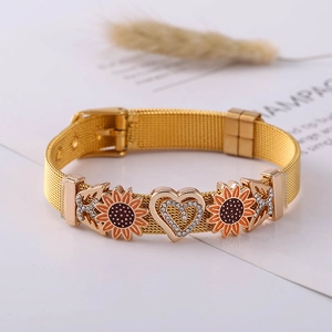 Detail eines goldenen Netzarmbands mit Sonnenblumen und Herz-Diamant-Akzenten
