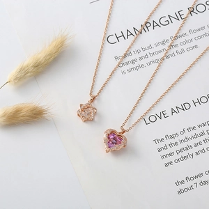 Detailed view of rose gold star and pink heart pendants with sparkling zircon settings