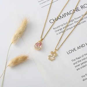 Macro detail of gold bear pendant with cubic zirconia and pink stone necklace