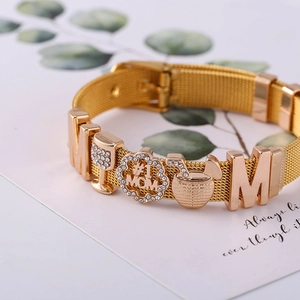Makroaufnahme Goldarmband mit #1 MOM und Buchstaben M Strass-Anhängern Detail