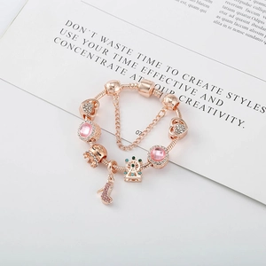 Détail du bracelet maille serpent or rose avec perles roses et breloques couronne