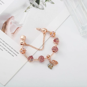 Détail du bracelet rose doré avec pampilles feuille d'érable et cœur sur chaîne maille