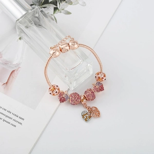 Détail du bracelet maille serpent en or rose avec charms zircons roses et cœur