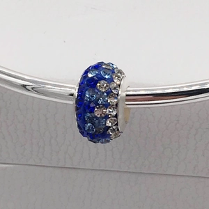 Close-up of Shamballa crystal charm with royal blue and silver rhinestones on a snake chain