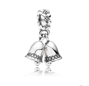Detail of silver Christmas bell charms with heart texture and reflective metal surface