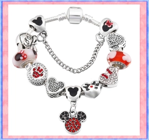 Macro shot of silver charm bracelet showing S925 hallmark on Disney-style Mickey pendants