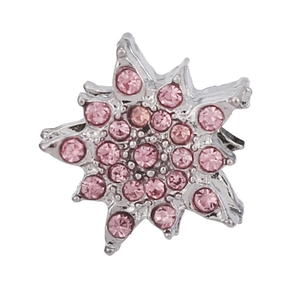 Macro detail of snowflake pendant featuring silver base and sparkling pink rhinestones