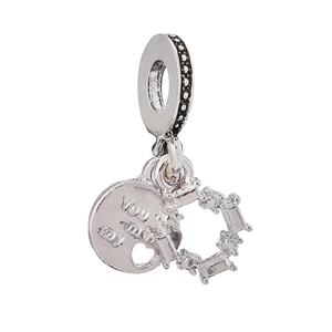 Detail of silver charm with You and Me engraving and rectangular cubic zirconia stones