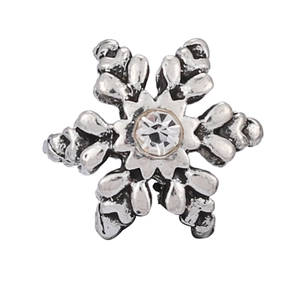 Macro view of vintage silver snowflake charm with a sparkling central cubic zirconia stone