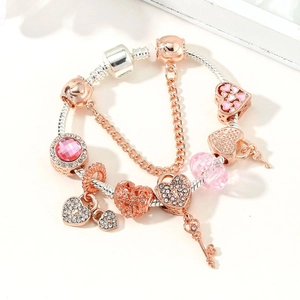 Macro detail of rose gold snake chain bracelet with heart charms and crystal beads