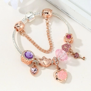 Detail of rose gold and silver snake chain bracelet with purple charms and heart charms