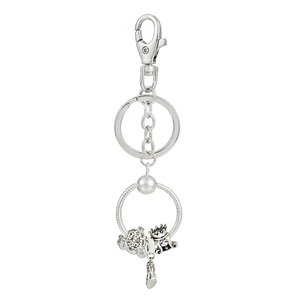 Close-up of silver keychain with Cinderella carriage, crown, and high heel charms