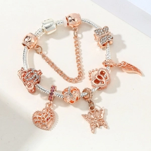 Detail of silver snake chain bracelet with rose gold pumpkin carriage and tree charms