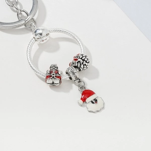 Macro detail of silver keychain featuring a Santa Claus enamel charm and Fashion engraving